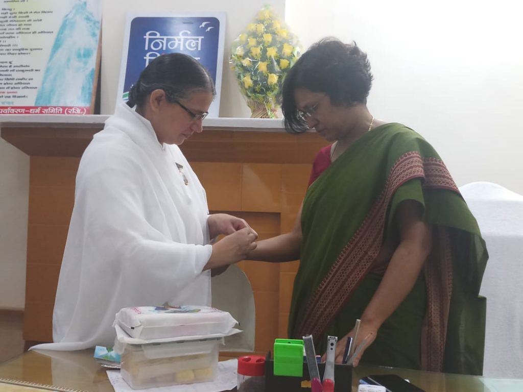 BK Sunita Bahen Tying Rakhi to Anita Mishra Commissioner, Meerut & Additional Commissioner Uday Raj